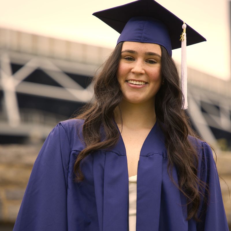 Smiling graduate in a navy cap and gown